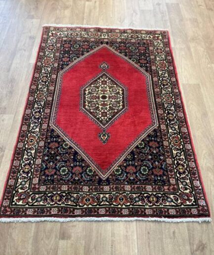 Red patterned rug on wooden floor